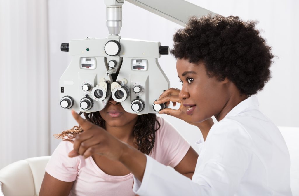 A woman at her optometrist's getting a comprehensive eye exam looking for refractive errors