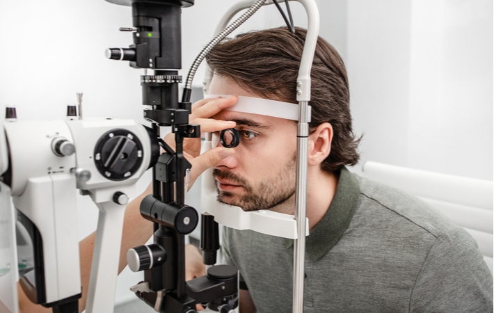 A man undergoing a slit lamp examination to check up on his overall eye health