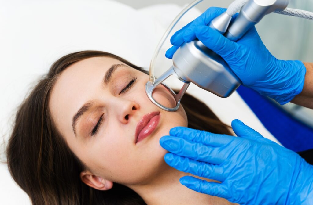 A patient closes their eyes as they undergo CO2 laser treatment.